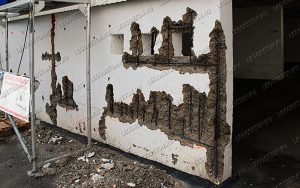 финальная стадия коррозии металлической арматуры в несущей стене с разрушением защитного бетонного слоя. Частичная потеря несущей способности стены с необходимостью дорогостоящей реконструкции. Отсутствие фиксаторов защитного слоя арматуры при строительстве.