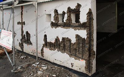 финальная стадия коррозии металлической арматуры в несущей стене с разрушением защитного бетонного слоя. Частичная потеря несущей способности стены с необходимостью дорогостоящей реконструкции. Отсутствие фиксаторов защитного слоя арматуры при строительстве.