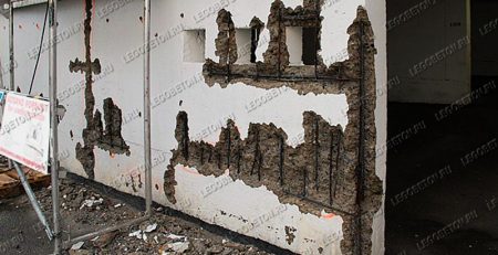 финальная стадия коррозии металлической арматуры в несущей стене с разрушением защитного бетонного слоя. Частичная потеря несущей способности стены с необходимостью дорогостоящей реконструкции. Отсутствие фиксаторов защитного слоя арматуры при строительстве.